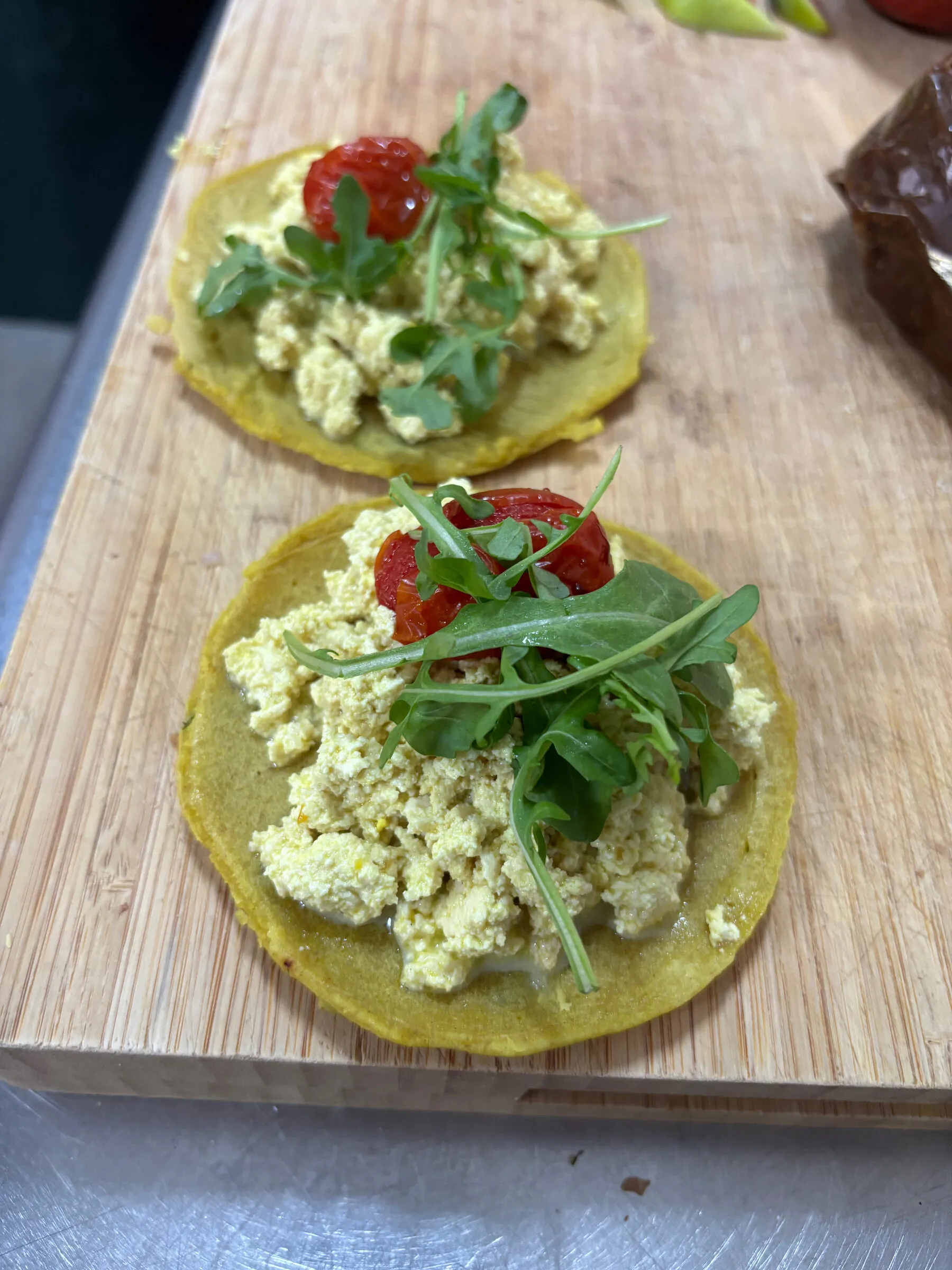 Buckwheat pancakes topped with scrambled tofu, roasted cherry tomato and rocket